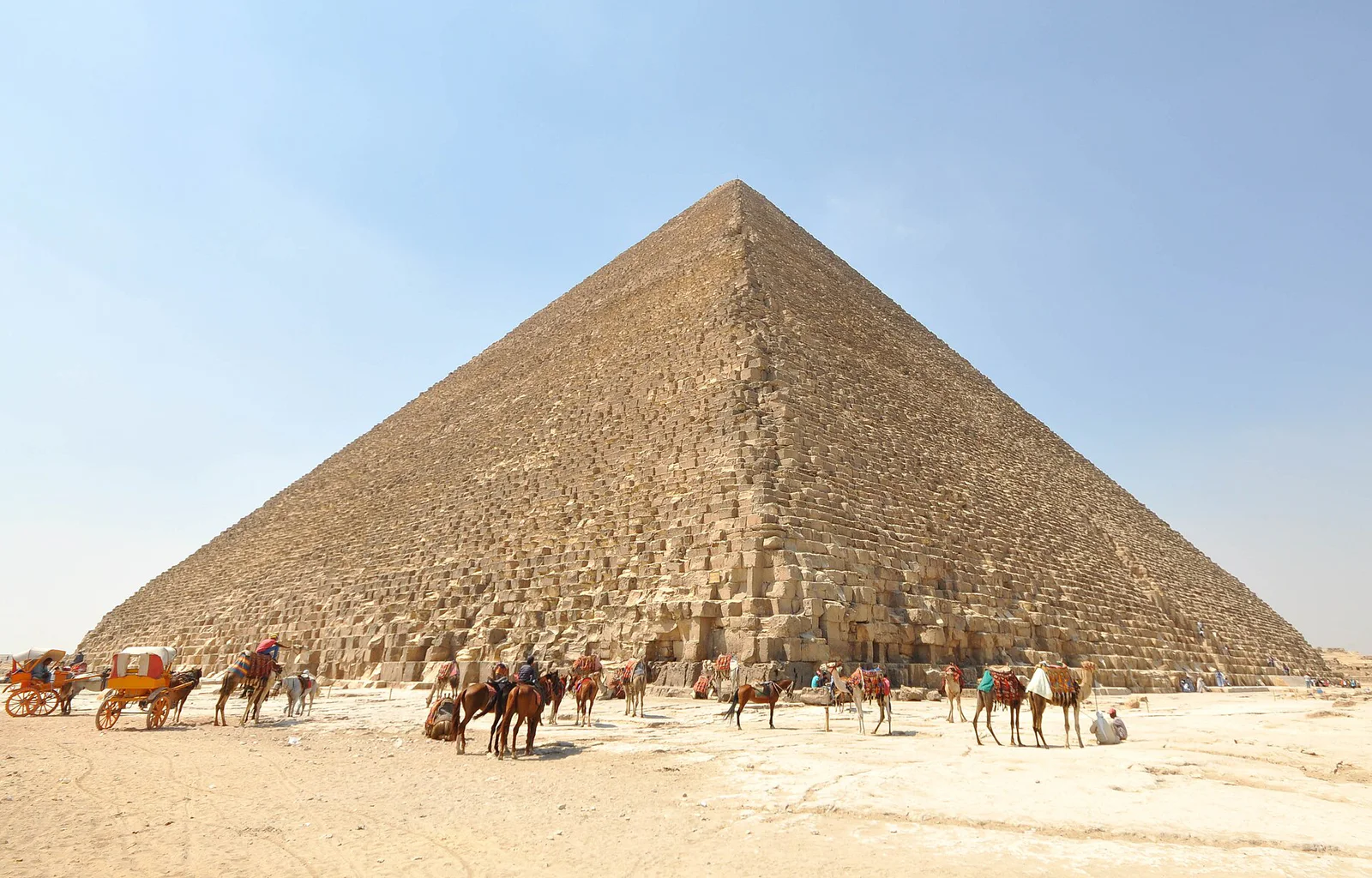 Seen from the edge of the Giza Plateau, the Great Pyramid still dominates the horizon with its vast stepped core exposed, a reminder that Khufu’s monument was once sheathed in smooth white Tura limestone that caught the desert light.